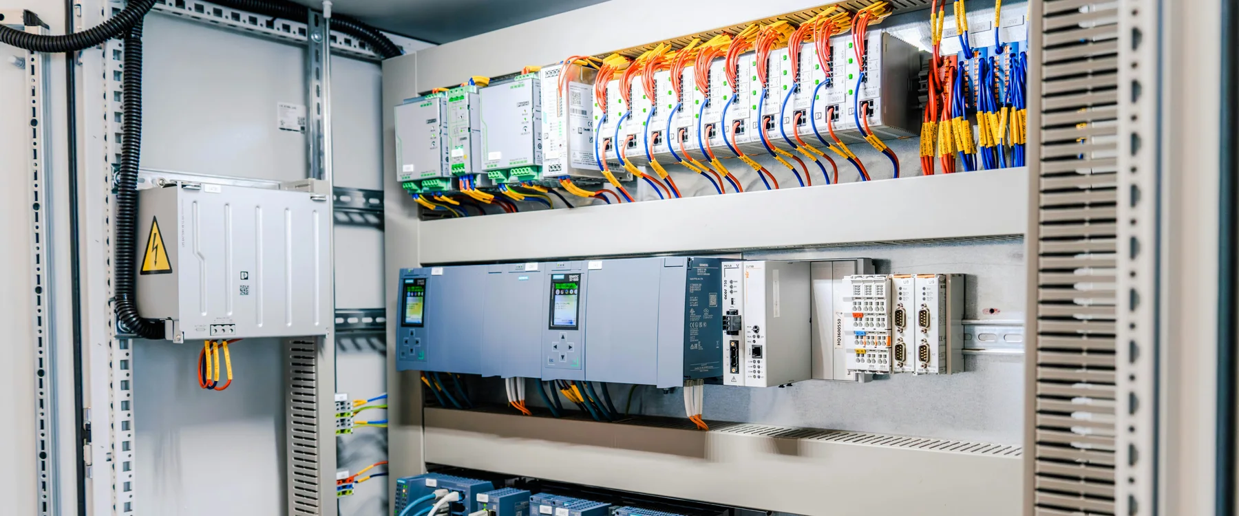 Industrial control cabinet with labeled wiring, control modules, drives and terminal blocks